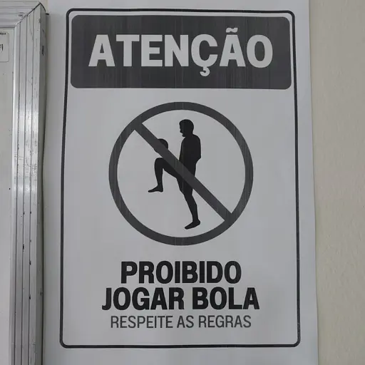 Placa que diz: "Atenção, proibido jogar bola, respeite as regras."

No meio tem um desenho de um cara dando embaixadinhas no joelho com sinal de proibido em volta, e por causa disso o desenho fica suspeito se não olhar direito.