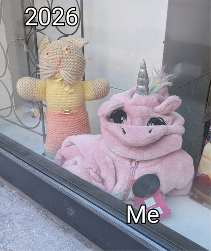 A shop window featuring a little cat that looks happy, and next to it a unicorn costume slumped over itself and looking desperate